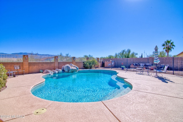 view of swimming pool with pool water feature and a patio