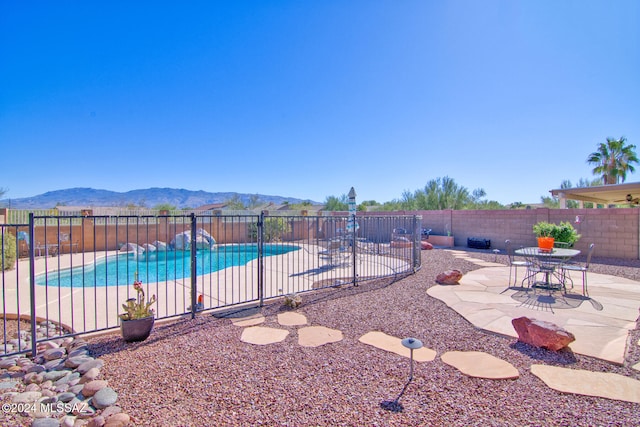 view of swimming pool with a mountain view and a patio