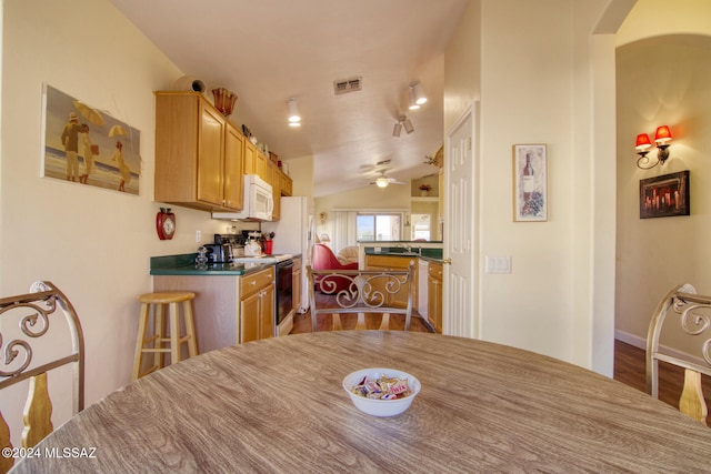 dining space with wood-type flooring, ceiling fan, lofted ceiling, and sink