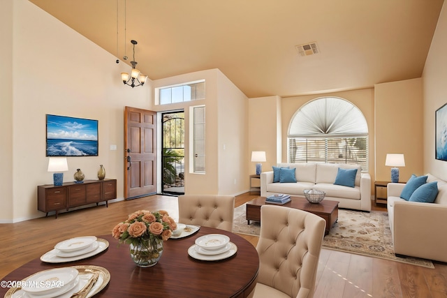 interior space featuring high vaulted ceiling, light hardwood / wood-style floors, and a chandelier