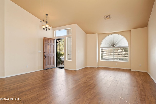 entrance foyer featuring hardwood / wood-style flooring, a chandelier, and a towering ceiling