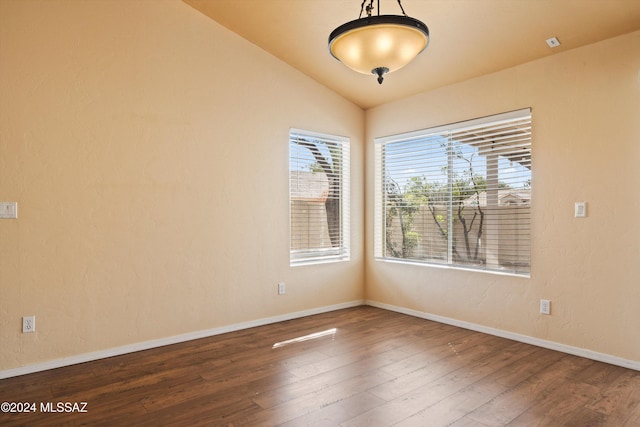 empty room with vaulted ceiling and hardwood / wood-style floors