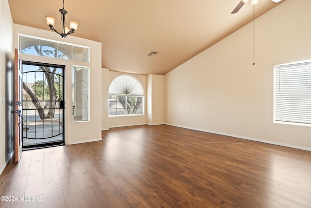 entryway with wood-type flooring, ceiling fan with notable chandelier, and high vaulted ceiling