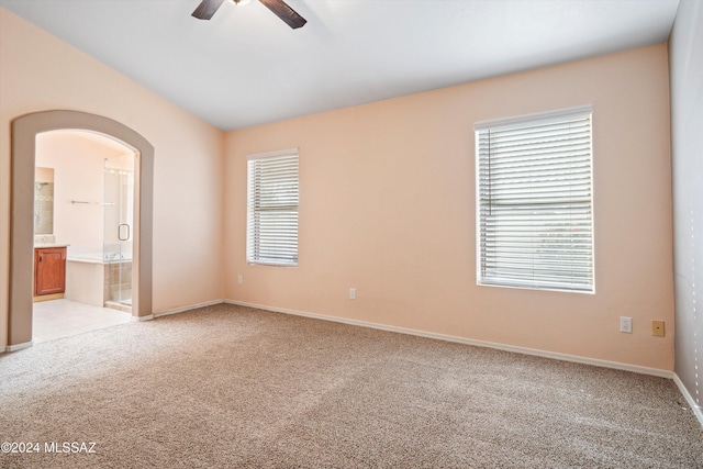 carpeted empty room featuring vaulted ceiling and ceiling fan