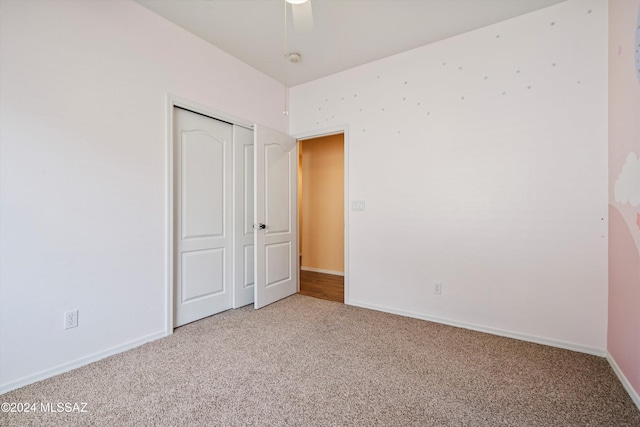 unfurnished bedroom featuring carpet floors, ceiling fan, and a closet