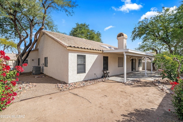 rear view of property featuring central AC unit and a patio area