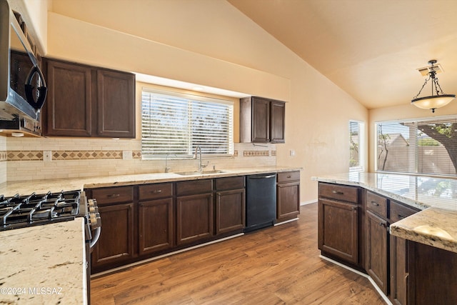 kitchen featuring lofted ceiling, sink, tasteful backsplash, decorative light fixtures, and appliances with stainless steel finishes