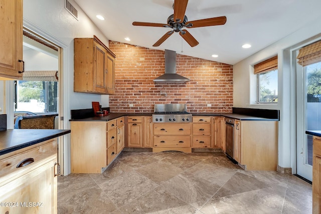 kitchen with dishwasher, wall chimney range hood, vaulted ceiling, ceiling fan, and brick wall