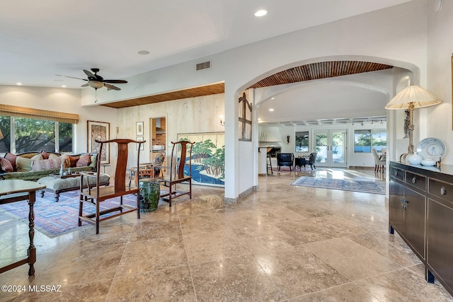 living room with a wealth of natural light, ceiling fan, and french doors