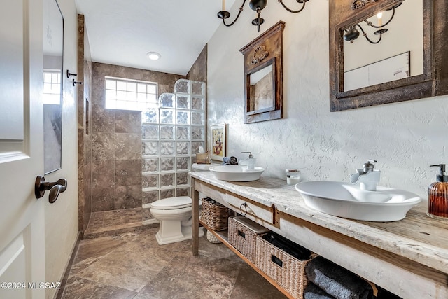 bathroom featuring tiled shower, vanity, and toilet