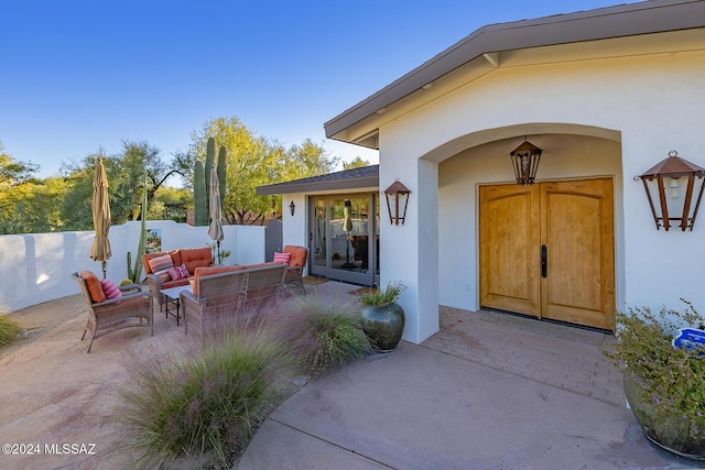 view of exterior entry featuring an outdoor hangout area and a patio area