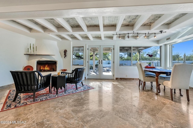 dining room with a fireplace, french doors, track lighting, and beamed ceiling