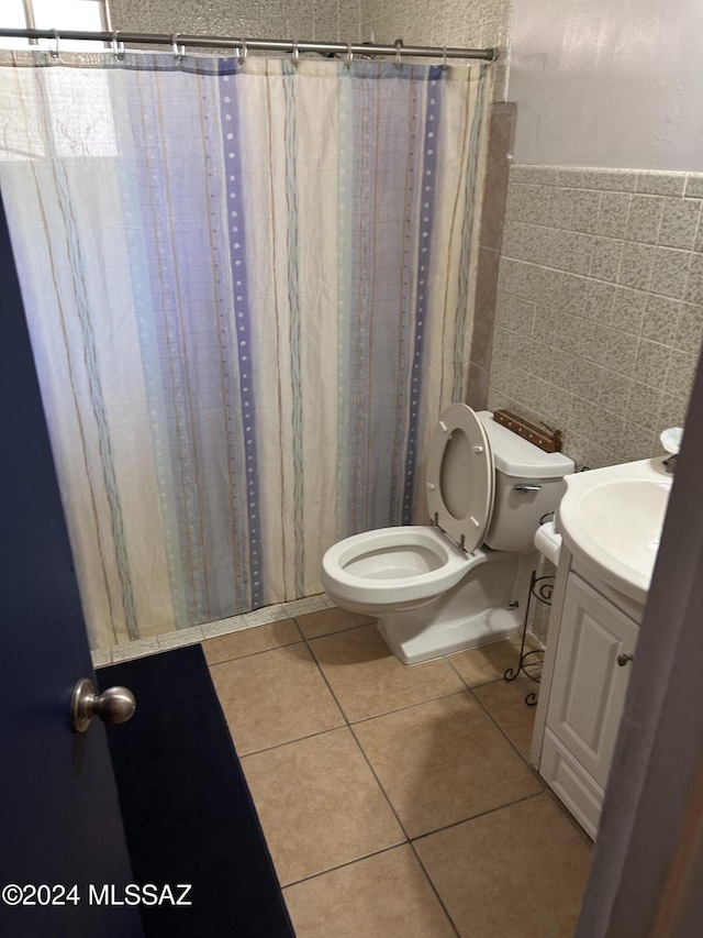 bathroom with tile patterned floors, toilet, tile walls, and vanity