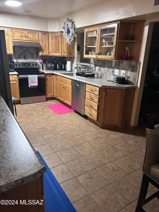 kitchen featuring backsplash, stainless steel appliances, and light tile patterned flooring