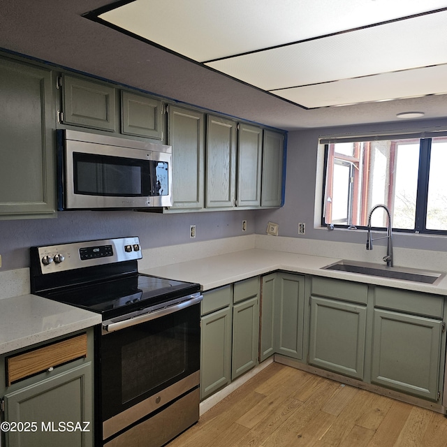 kitchen with sink, light hardwood / wood-style floors, and appliances with stainless steel finishes