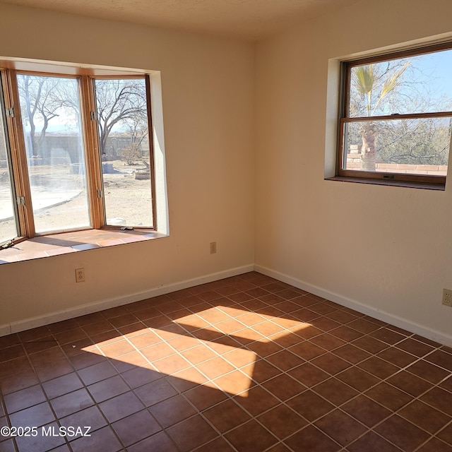 tiled empty room featuring plenty of natural light