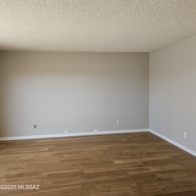 spare room with hardwood / wood-style floors and a textured ceiling