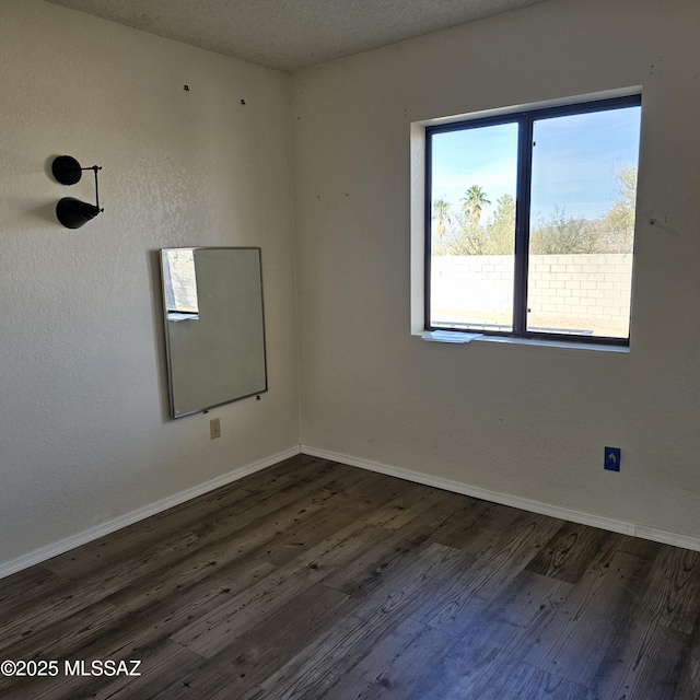 unfurnished room with dark hardwood / wood-style floors and a textured ceiling