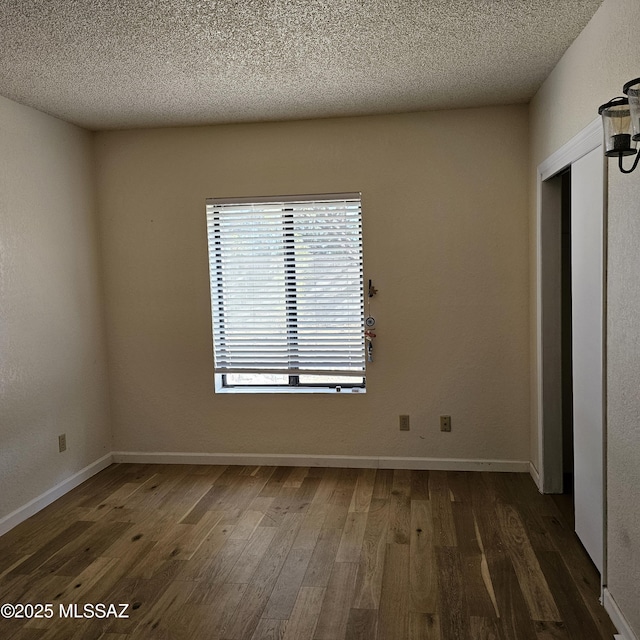 unfurnished bedroom featuring dark wood-type flooring, a textured ceiling, and a closet