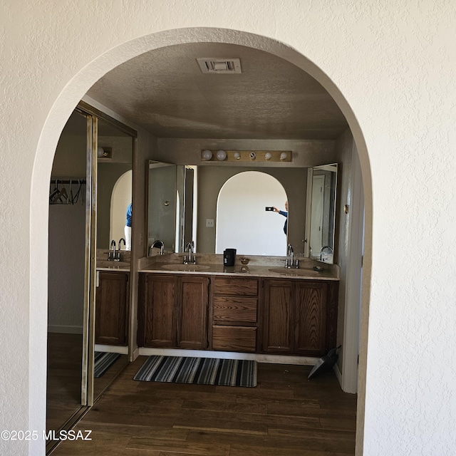 bathroom featuring vanity, hardwood / wood-style floors, and a textured ceiling