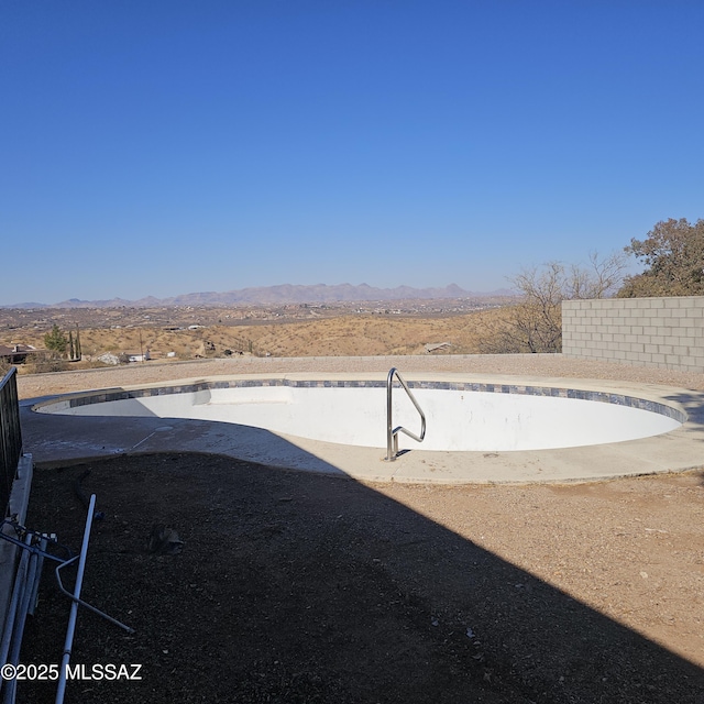 view of yard featuring a mountain view and an empty pool