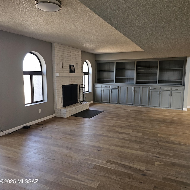 unfurnished living room with hardwood / wood-style flooring, plenty of natural light, and a fireplace