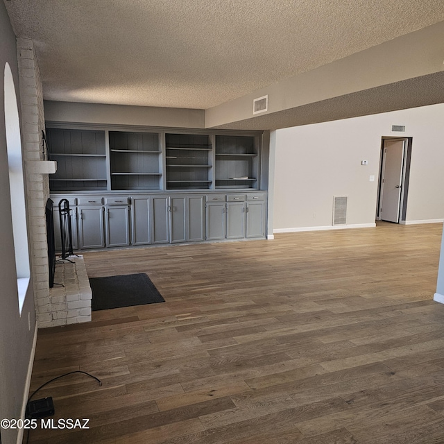 unfurnished living room with hardwood / wood-style flooring and a textured ceiling