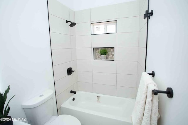 bathroom with toilet and tiled shower / bath