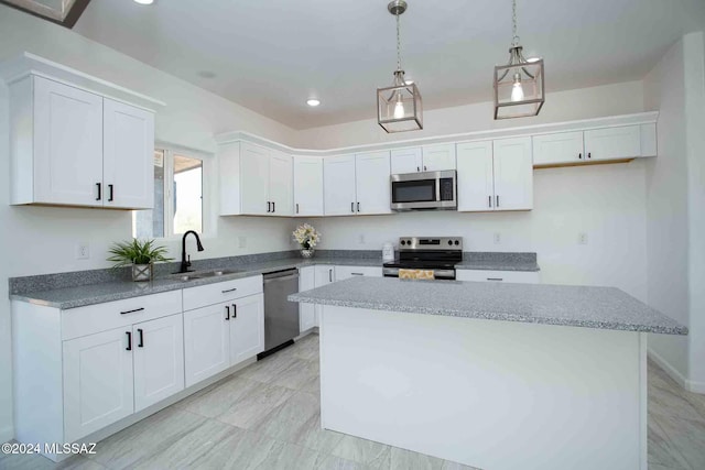 kitchen with a kitchen island, white cabinetry, sink, and appliances with stainless steel finishes