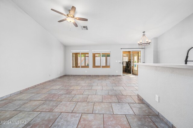 unfurnished living room featuring ceiling fan with notable chandelier and lofted ceiling