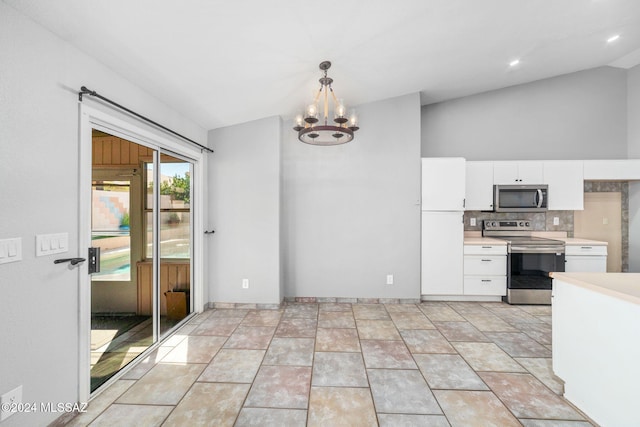 kitchen featuring white cabinetry, hanging light fixtures, lofted ceiling, and appliances with stainless steel finishes