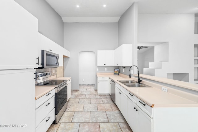 kitchen with white cabinets, ceiling fan, sink, and stainless steel appliances