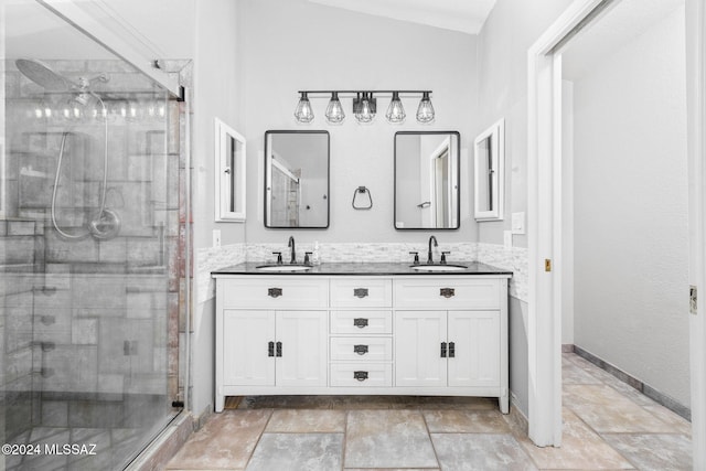 bathroom featuring vanity, vaulted ceiling, and a shower with door