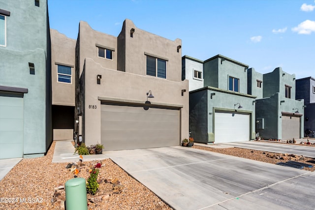 pueblo revival-style home with a garage