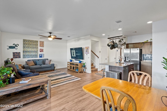 living room with ceiling fan and light hardwood / wood-style flooring