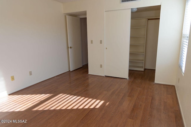 unfurnished bedroom featuring a closet and hardwood / wood-style flooring