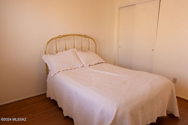 bedroom featuring dark wood-type flooring and a closet