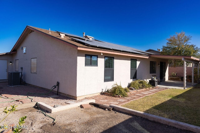 view of side of property featuring cooling unit, a patio, and solar panels