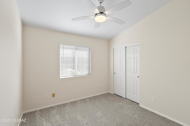 unfurnished bedroom with a closet, ceiling fan, light colored carpet, and lofted ceiling