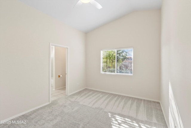 empty room with vaulted ceiling, ceiling fan, and light colored carpet