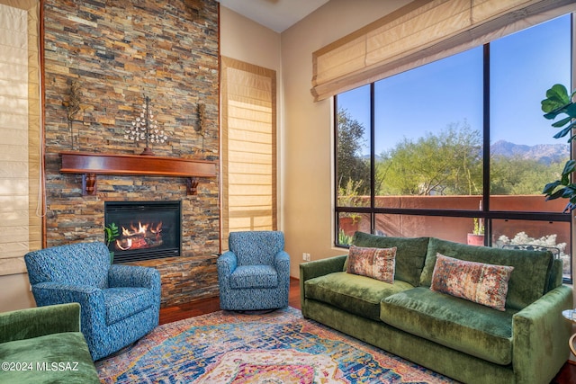 living room with a stone fireplace, a mountain view, and hardwood / wood-style floors