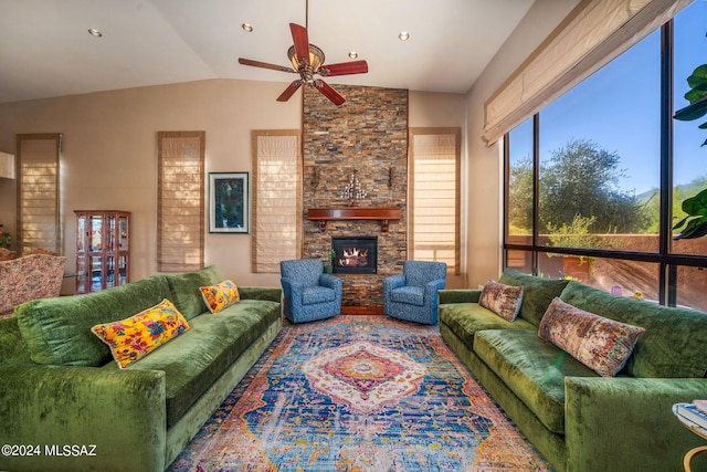 living room with a stone fireplace, ceiling fan, wood-type flooring, and lofted ceiling