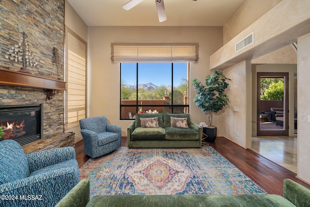 living room with ceiling fan, a fireplace, and dark hardwood / wood-style floors