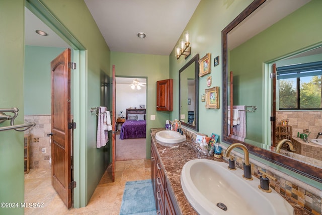 bathroom with tile patterned floors, vanity, ceiling fan, and a washtub