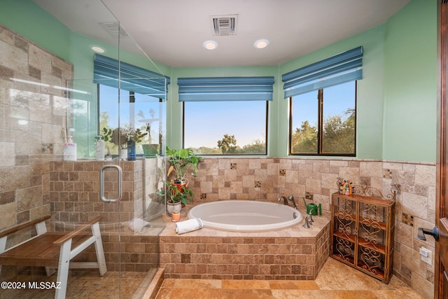 bathroom with separate shower and tub and tile walls