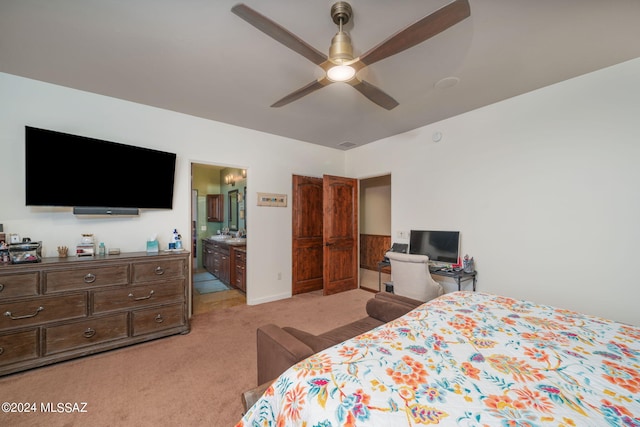 carpeted bedroom with ensuite bath and ceiling fan