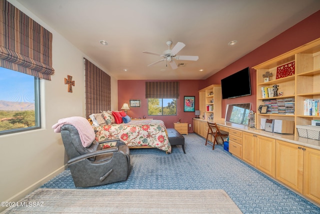 bedroom with ceiling fan and built in desk