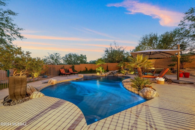 pool at dusk featuring a patio area