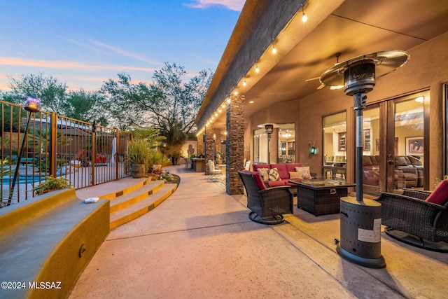 patio terrace at dusk with outdoor lounge area and ceiling fan