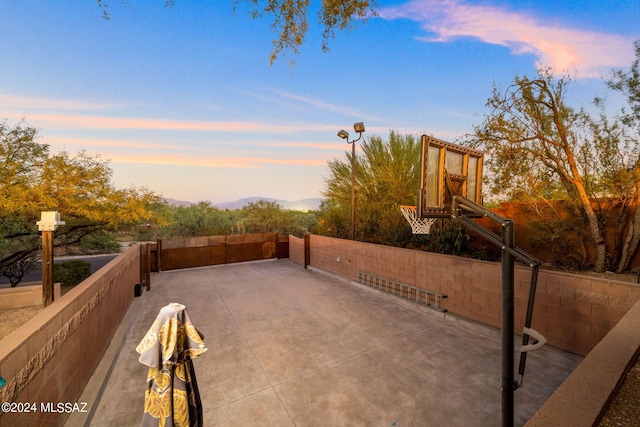 patio terrace at dusk featuring basketball court